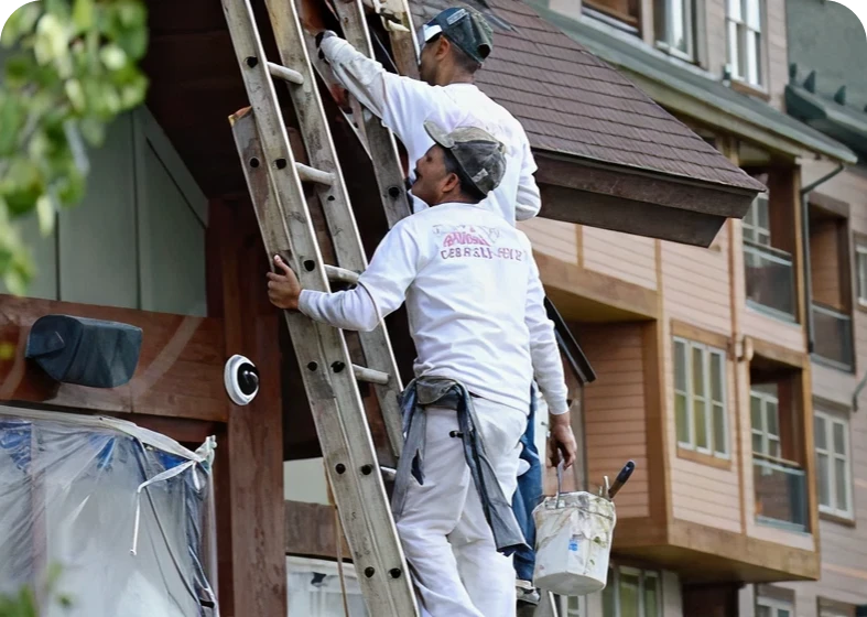 Two men painting house exterior
